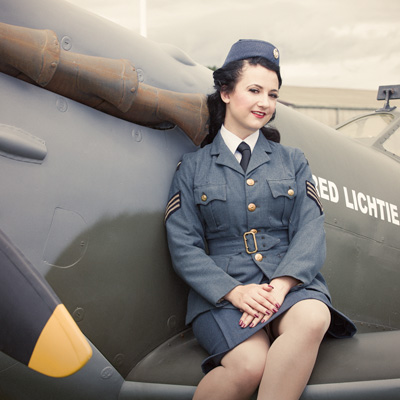 Kitri Du Lac wearing an RAF uniform, with the Red Lichtie Spitfire.